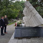 Przewodniczący Rady Miasta Mariusz Batorski i zastępca burmistrza Piotr Gąszcz stoją przed pomnikiem. Pomnik przedstawia wizerunek dużego białego orła w złotej koronie.